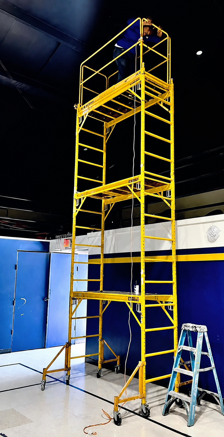 Tall indoor rolling scaffold tower set up for a high-ceiling project in North Dallas